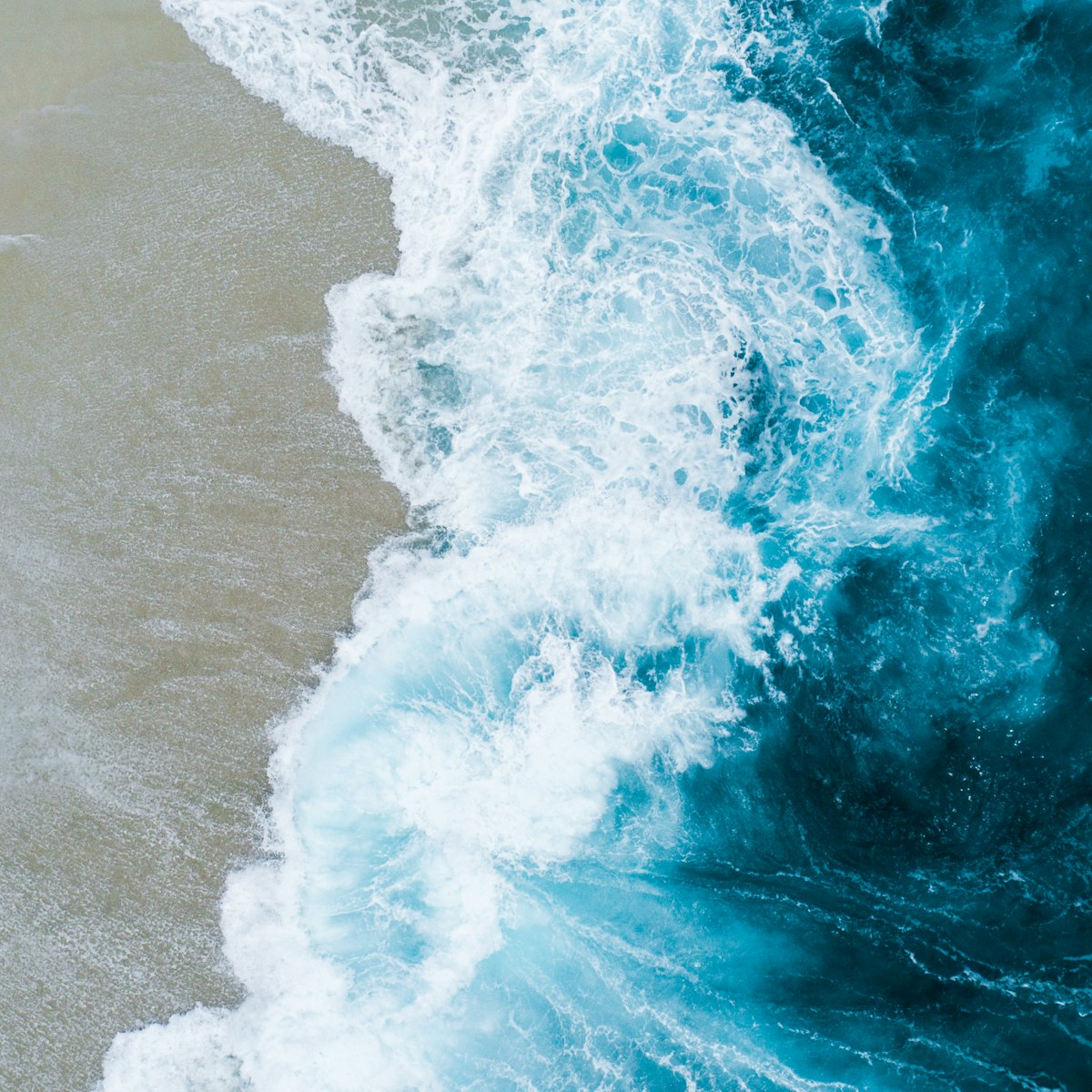 White sea foam swirling over sand