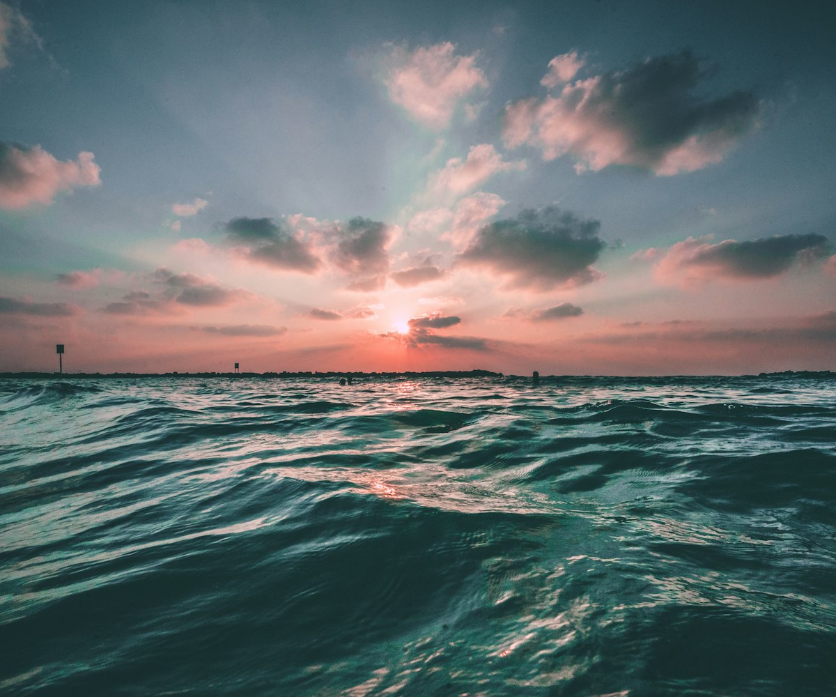 Teal ocean swell under a dusk sky