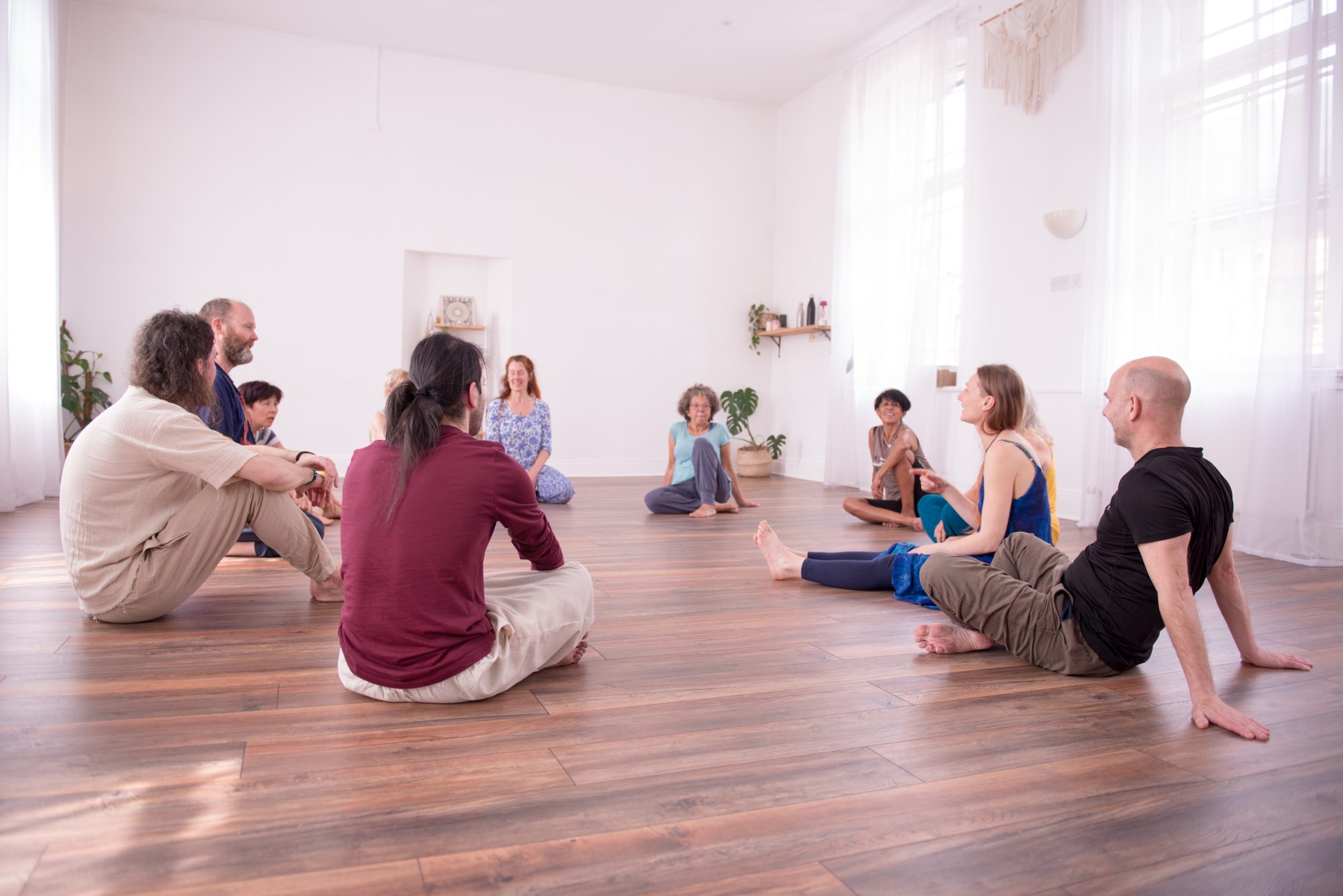 A group seated in a circle in a bright studio