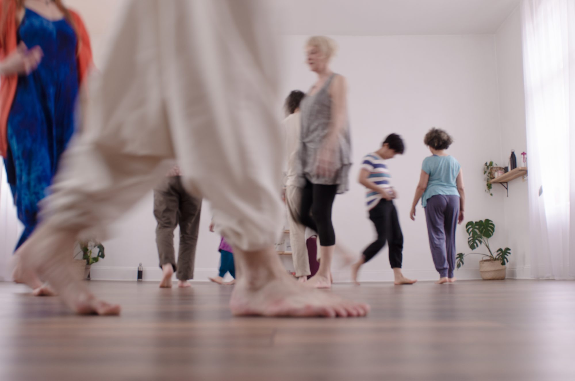 Bare feet crossing a wooden dance floor