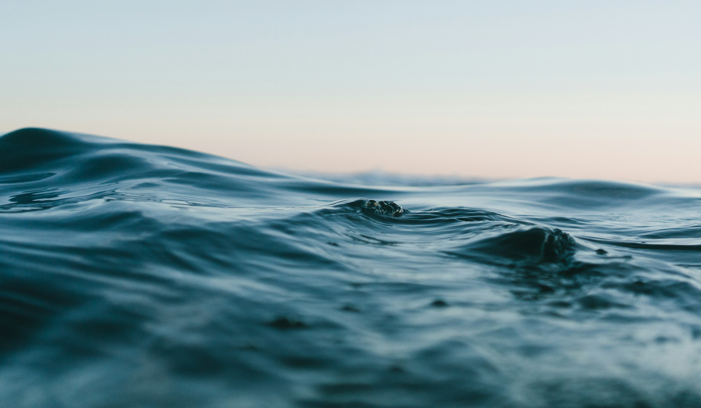 Calm sea at dusk, soft light on slow waves