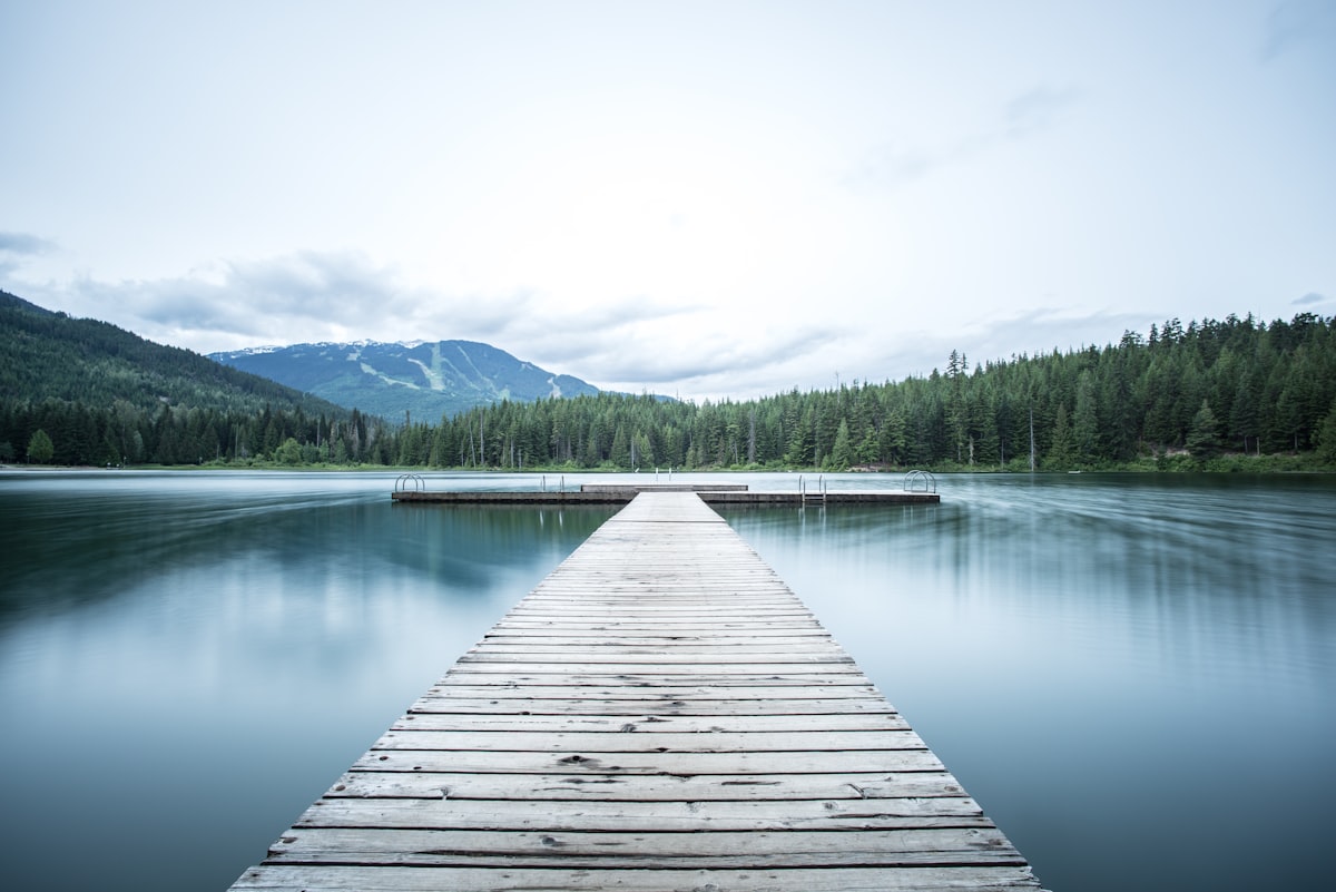 A wooden jetty reaching into still water